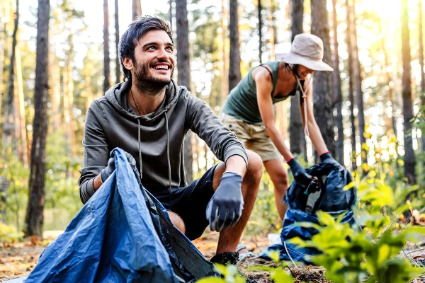 Pärchen räumt Müll aus dem Wald